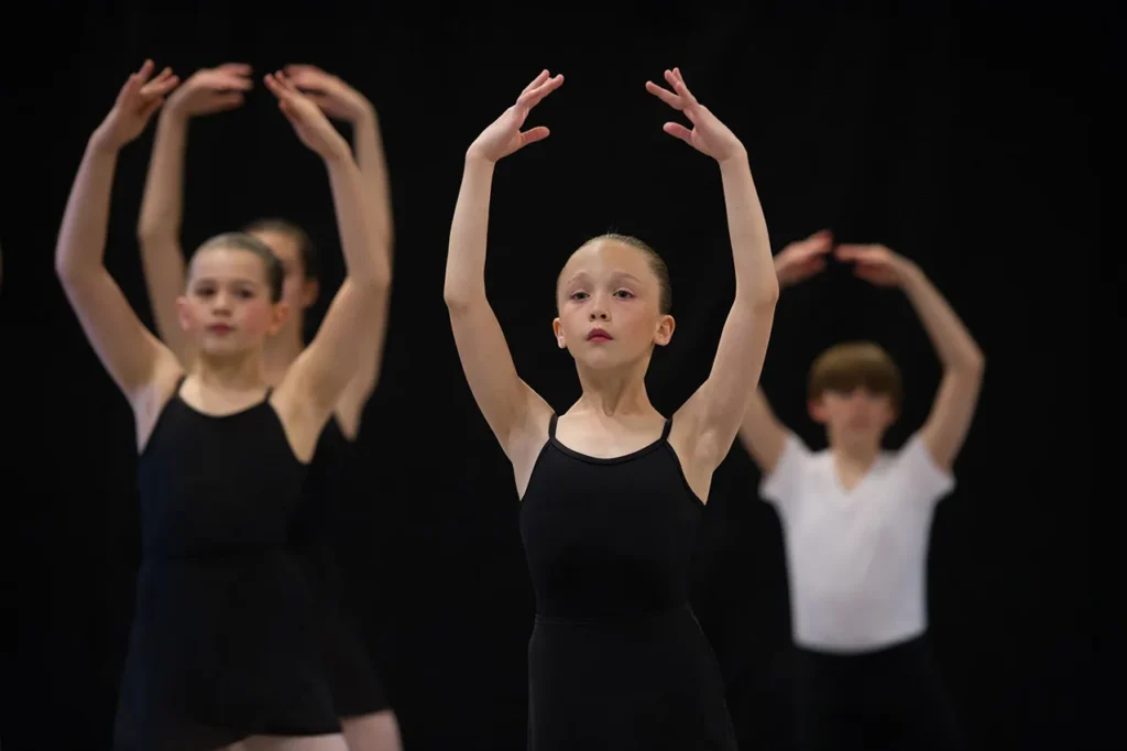 Group of ballet students during adagio in center